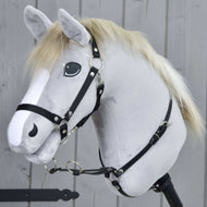 The Martingale black by Hobby Horse LarDen is a realistic grey hobby horse toy with a light mane, white blaze, and black bridle, mounted on a wooden stick, shown in front of a grey wooden fence.