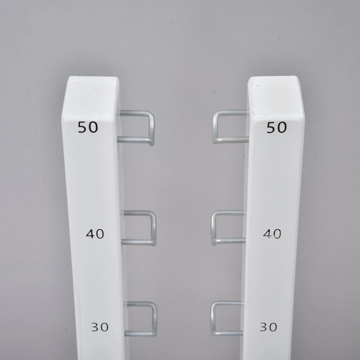The Hobby Horse LarDen Jump 50 cm / 20 inch features two white vertical metal bars with hooks labeled 30, 40, and 50 in black. Perfect adjustable obstacle for hobby horsing jumps—great for both indoor and outdoor use.
