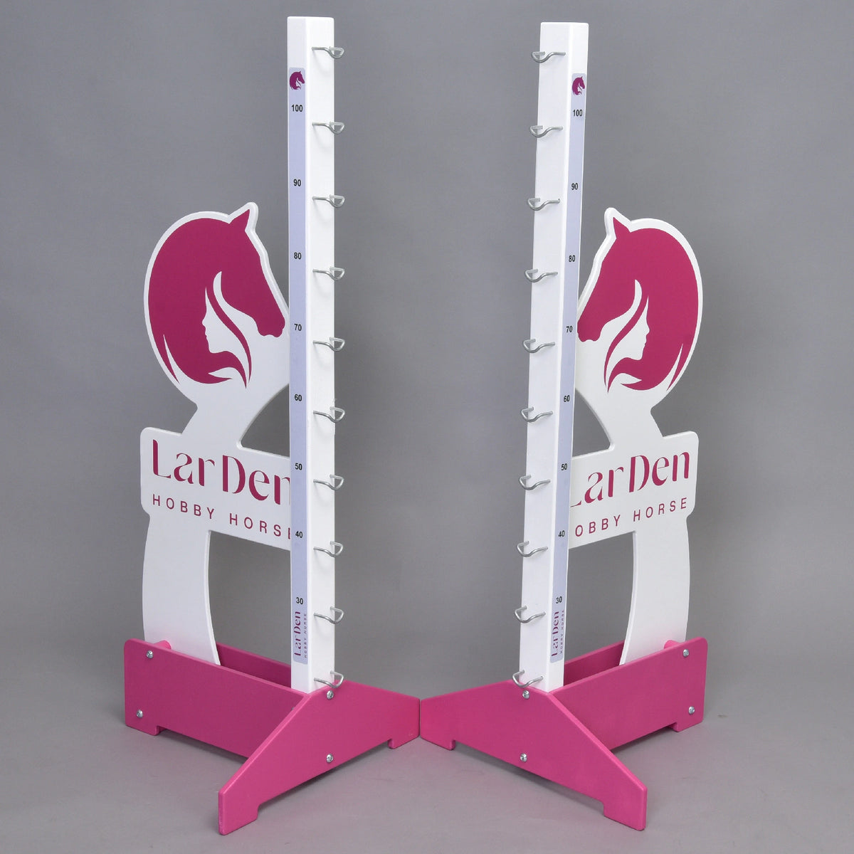 Both stands at an angle: white wings with the pink horse head and girl logo, LarDen lettering and pink cross feet