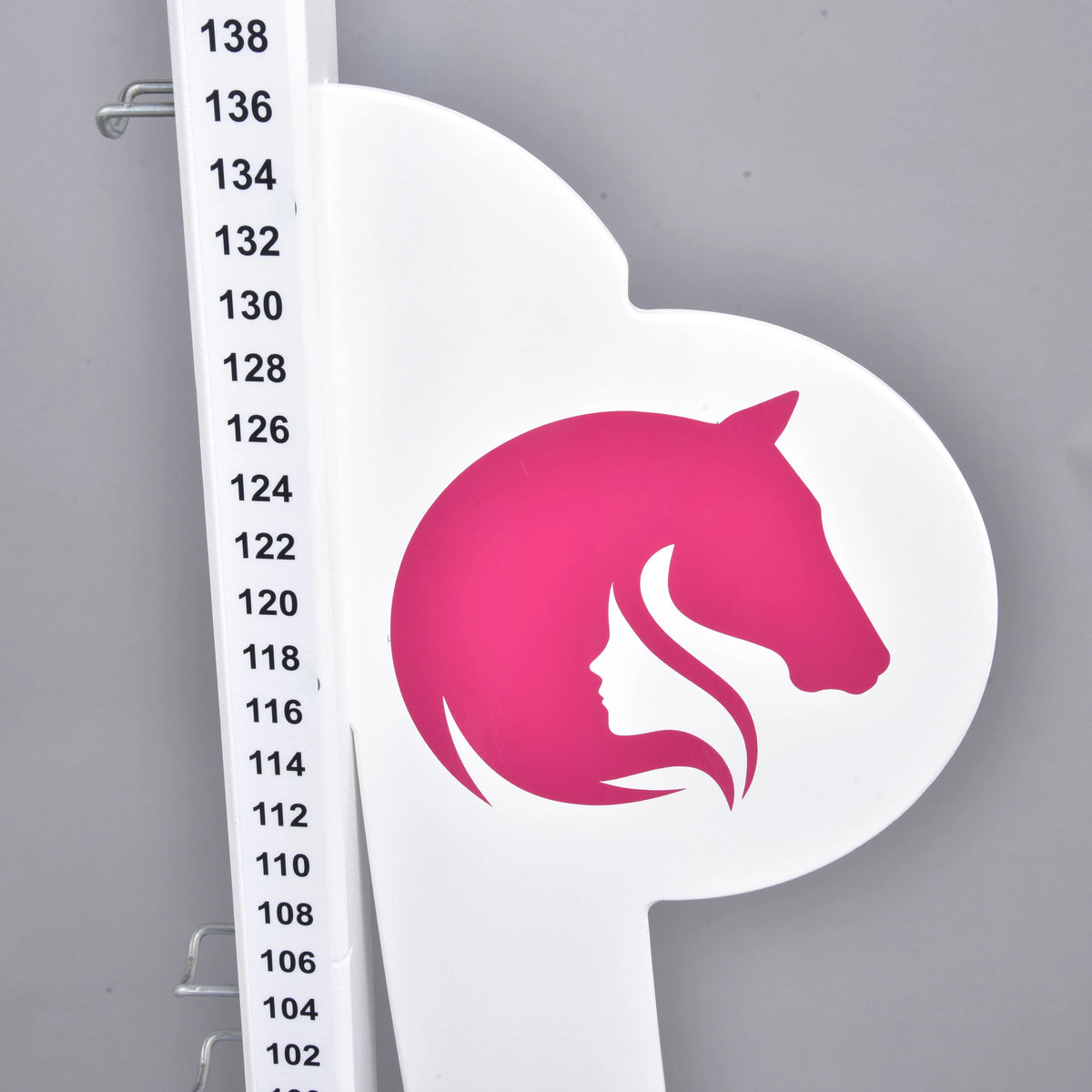 Detalje af et sidepanel med det lyserøde logo med hestehoved og pigeprofil ved skalaen fra 102 til 138 cm