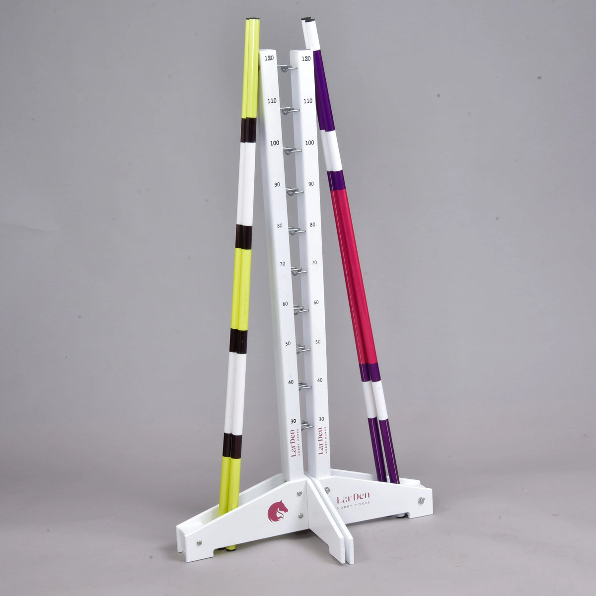 The Hobby Horse LarDen Jump set for Hobby Horsing includes white measuring stands with marked height increments and two striped poles—perfect for adjustable agility or jumping exercises.