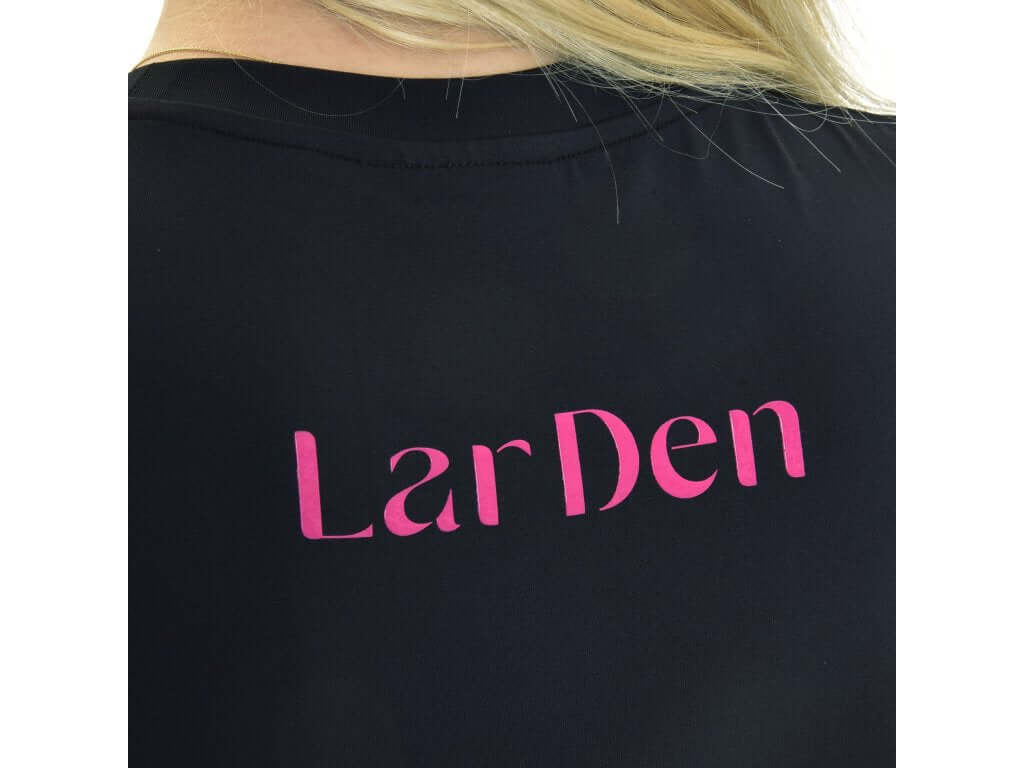 Close-up of the back of a T-Shirt LarDen Active Black by Hobby Horse LarDen, featuring bold pink "LarDen" lettering. Blonde hair partially covers the upper part of the shirt.