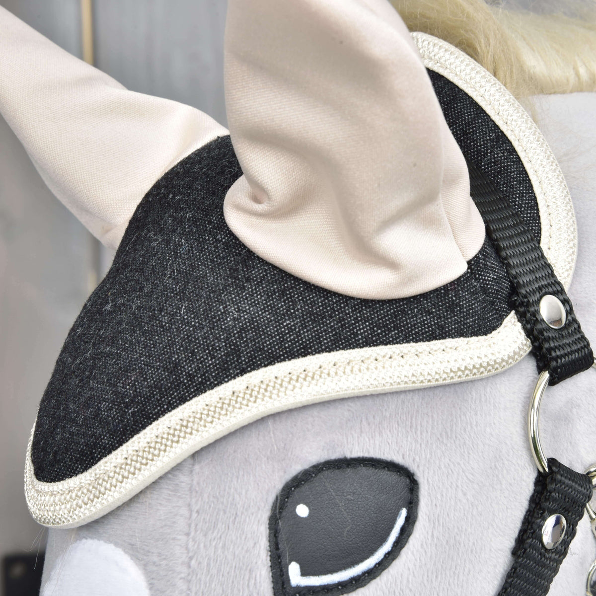 Close-up of the Hobby Horse LarDen Set Blue Denim’s head, showcasing a black bridle with white trim, cream ears, smooth gray surface, and embroidered eye—an adorable decoration for horse lovers.