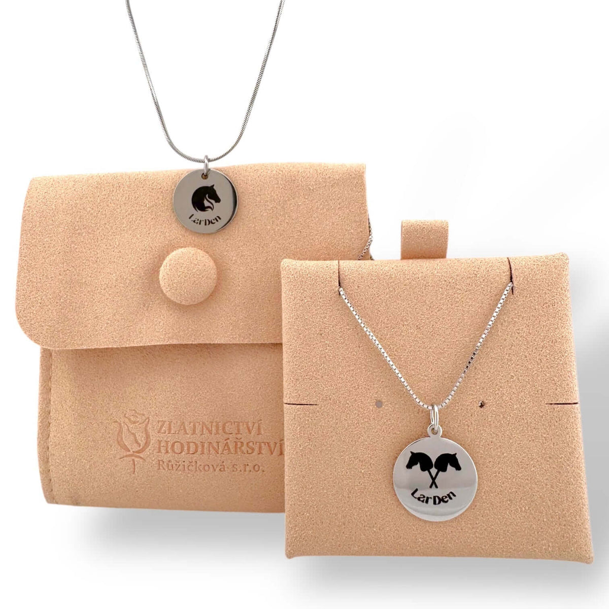The Hobby Horse LarDen Necklace features a round pendant with a horse silhouette and “Landon”, crafted from surgical stainless steel. Presented on a beige suede pouch and holder embossed with the brand logo—ideal for hobby horsing fans.