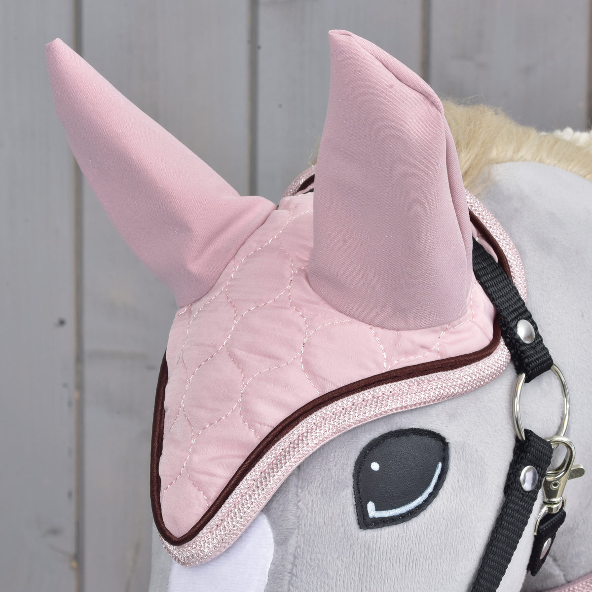 Close-up of the pink quilted ear bonnet worn by a grey Hobby Horse