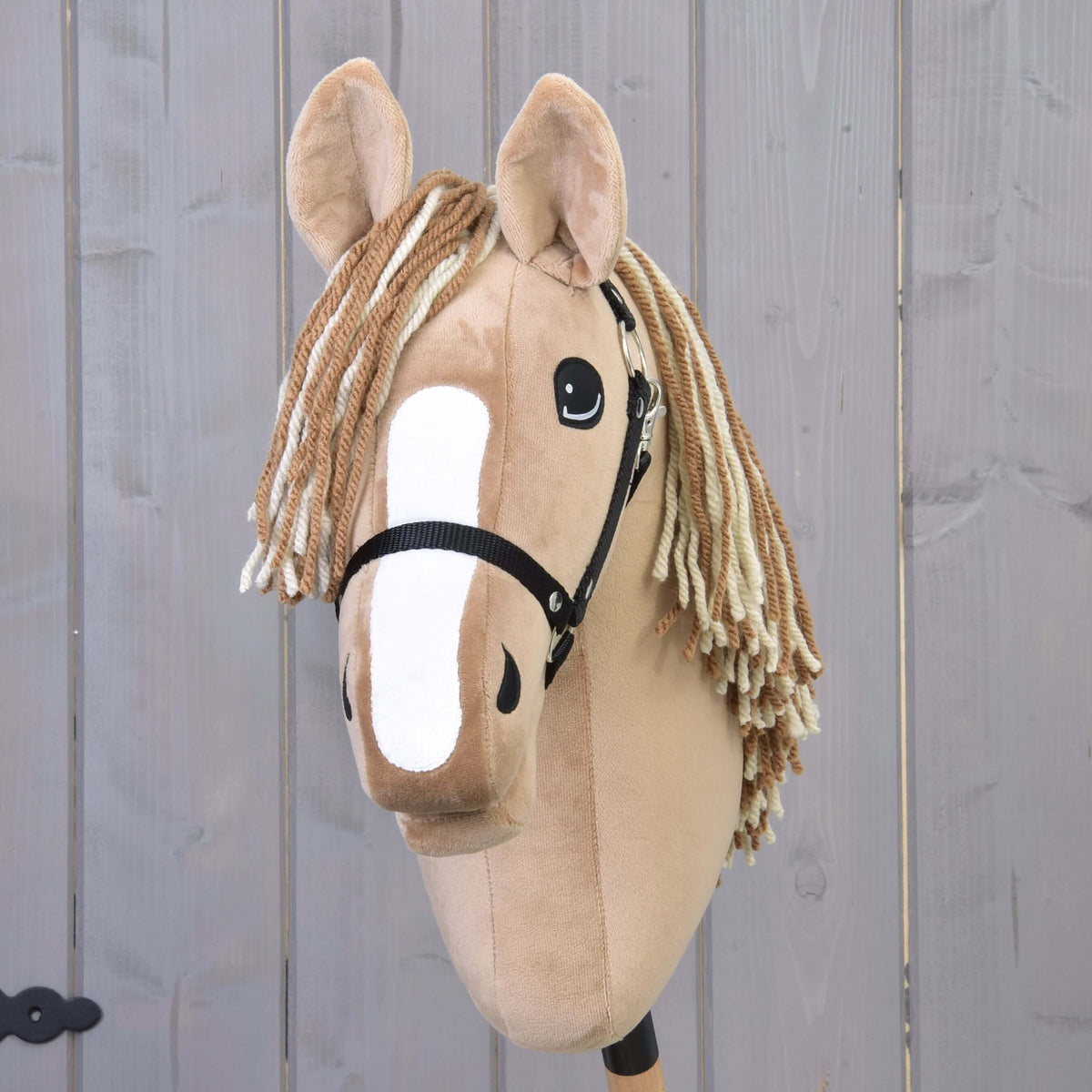 Hobby Horse Bren med sort grime set forfra med bred hvid blis og tofarvet pandelok af brunt og cremefarvet garn
