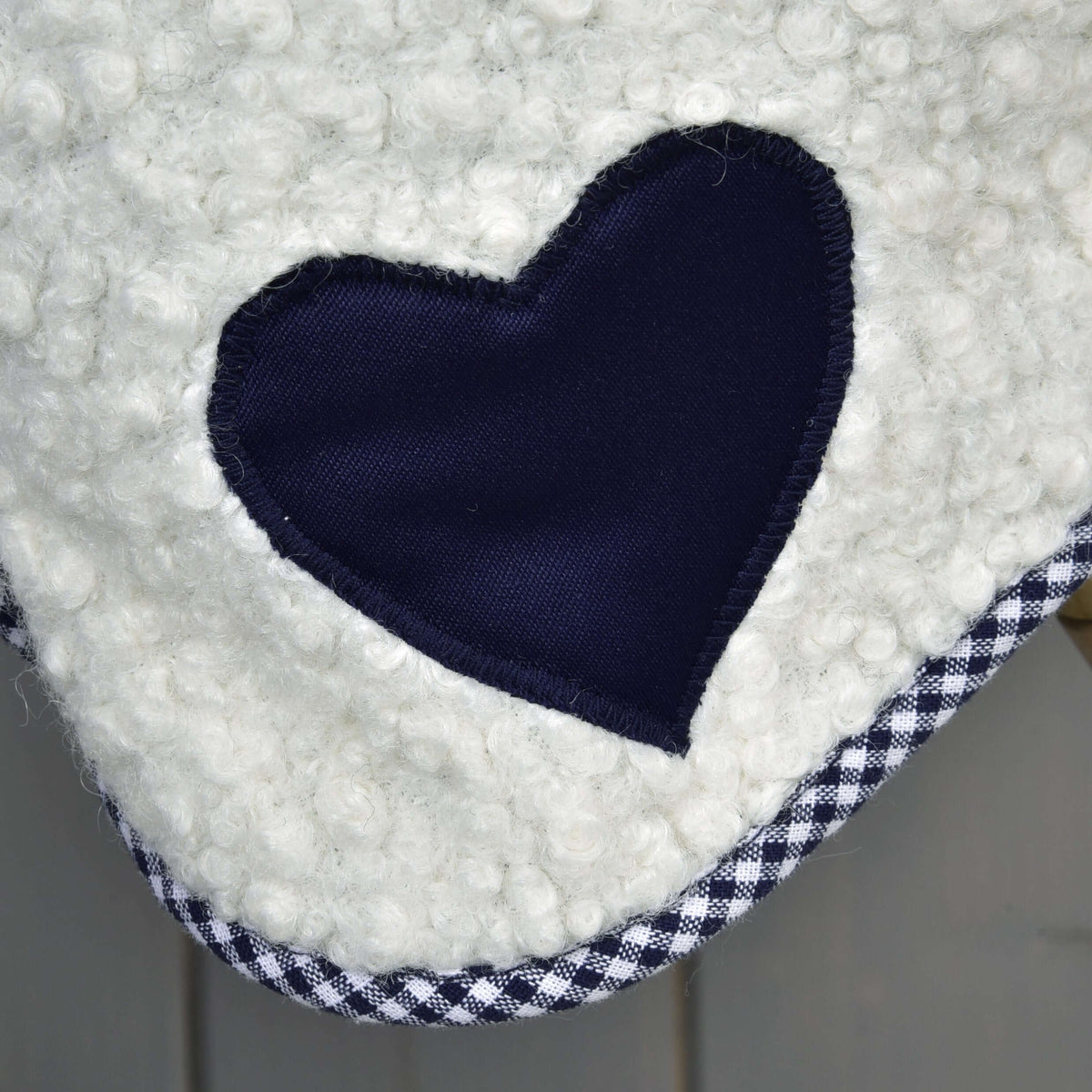 A close-up of Hobby Horse LarDen's Blanket cube blue—a white, textured fabric with a navy heart patch and black-and-white checkered trim, perfect as a hobby horse blanket.