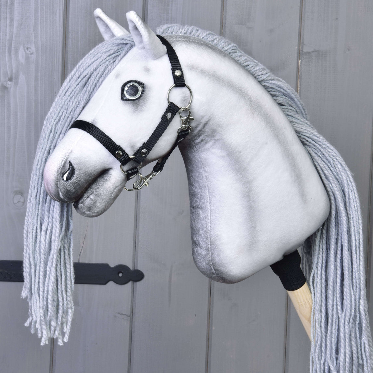 Hobby Horse enhjørning Silver vist uden horn med sort grime på en kæp foran grå brædder