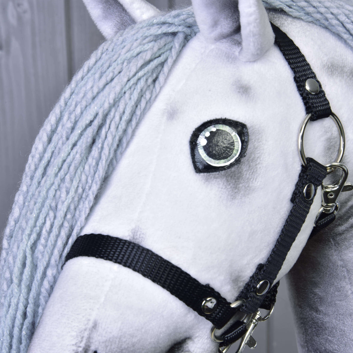 Tæt på øjet og den sorte grime på Hobby Horse enhjørning Silver med lysegrå manke af garn med fint sølvglimmer
