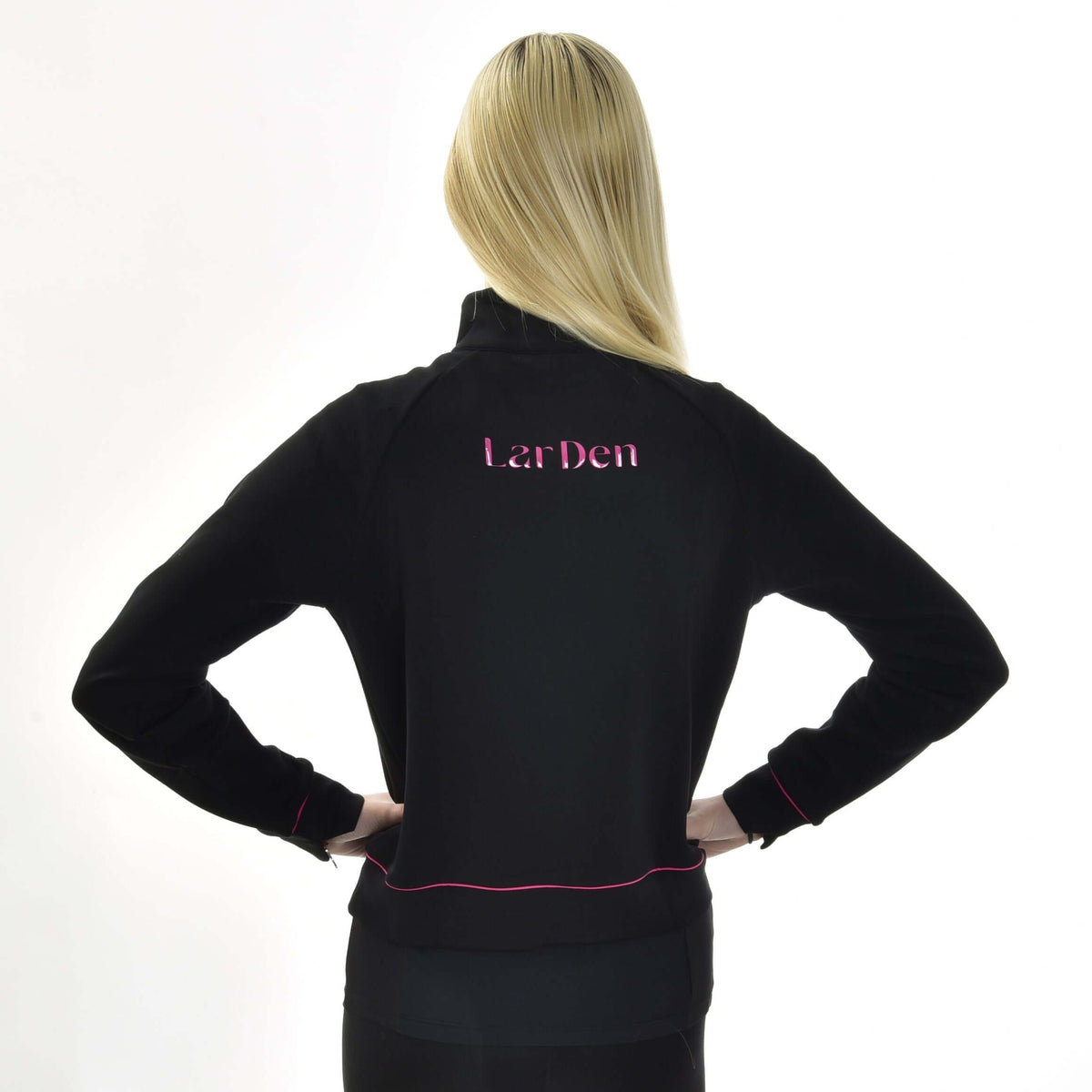 Lyshåret pige set bagfra med hænderne i siden i den sorte Hobby Horse LarDen sweatshirt med lyserød skrift på ryggen