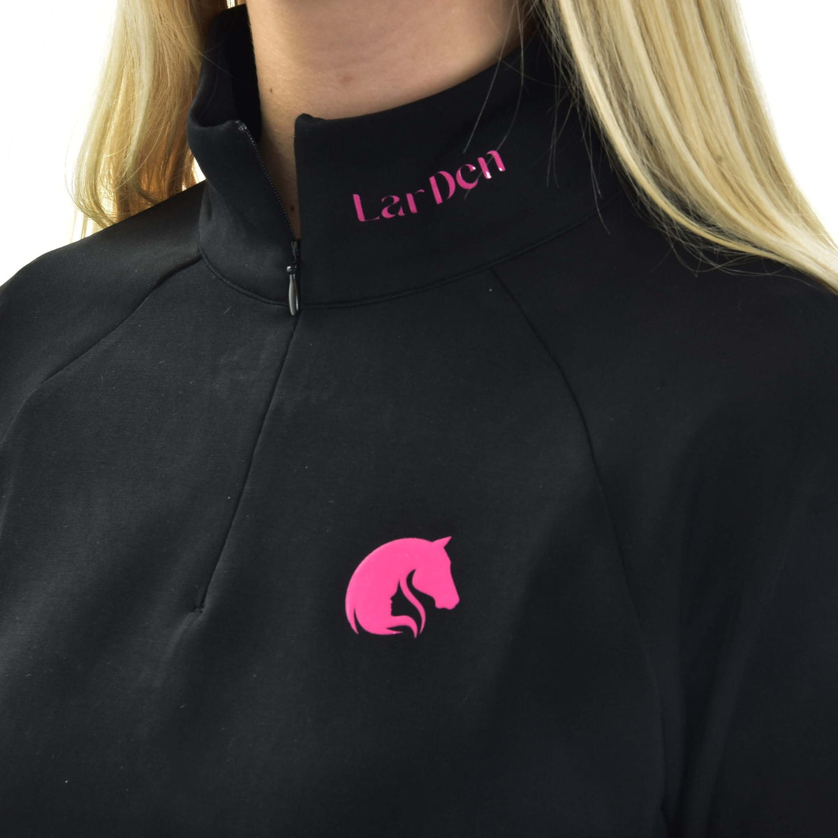 Detalje af Hobby Horse LarDen sweatshirten på en pige: høj krave med lynlås, lyserød skrift og lyserødt hestelogo
