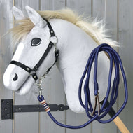 The Hobby Horse - Lunging Rope by Hobby Horse LarDen features a gray horse with a fluffy mane, cartoon-like eyes, black bridle, and blue lead rope on a wooden stick, displayed against a gray wooden wall.
