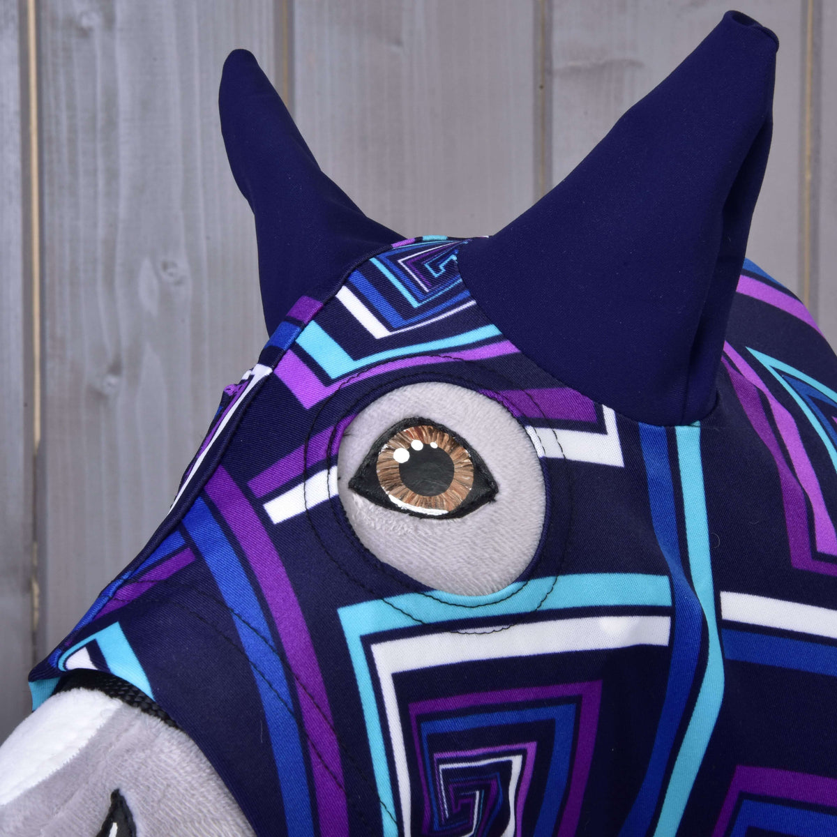 Close-up of the Hobby Horse protective suit blue (Lycra): navy ears and a round eye opening around the brown eye