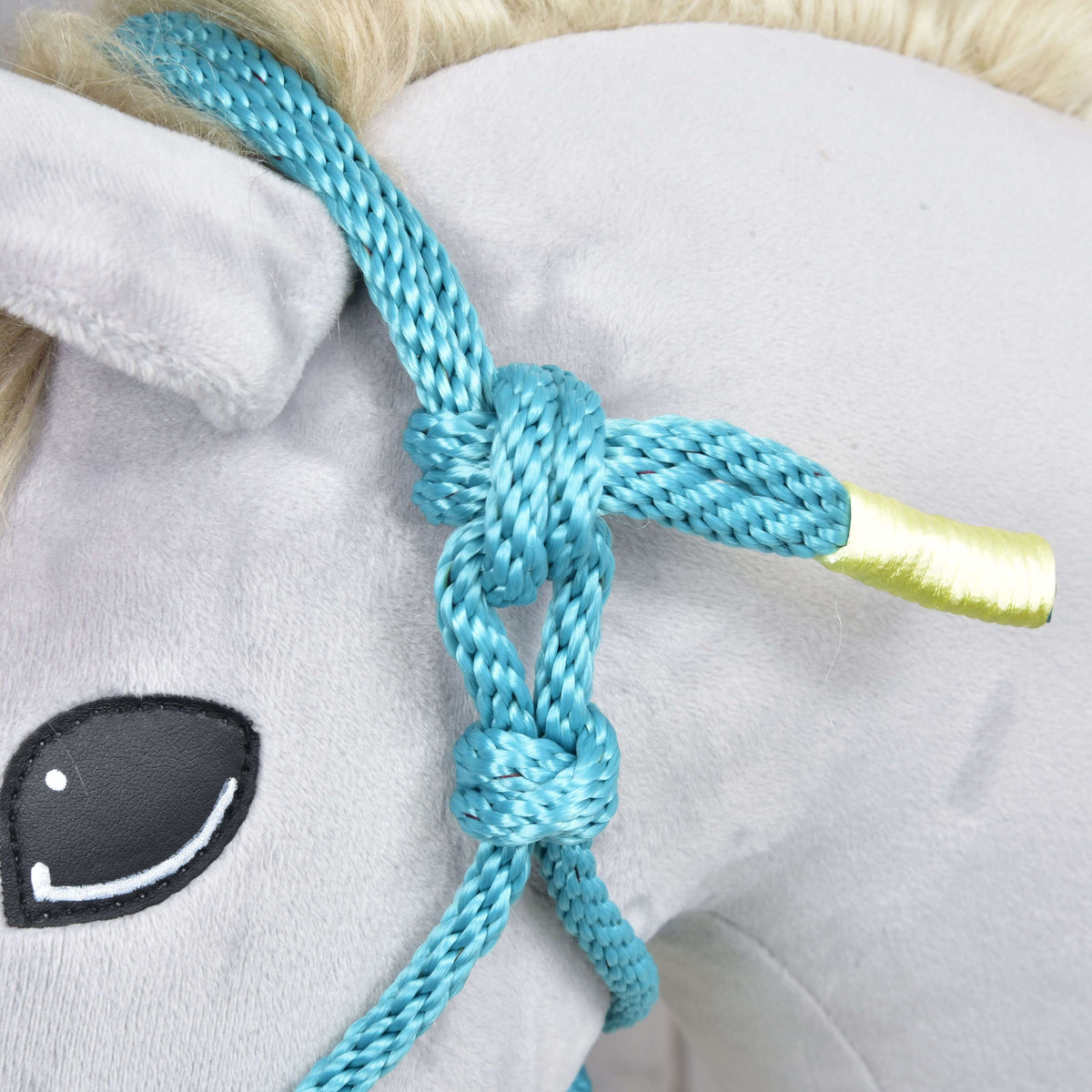 Close-up of Hobby Horse LarDen's Rope halter Turquoise on a plush hobby horse head, featuring a yellow-tipped ear, stitched black eye, and light mane—an adorable accessory for any hobby horse enthusiast.
