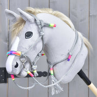 A gray hobby horse with a white blaze, black nose, and blond mane wears the Rope set Manhattan by Hobby Horse LarDen, featuring a gray rope halter and reins with colorful beads, shown against a wooden background.