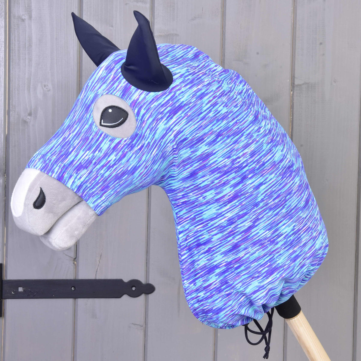 Hobby Horse beskyttelsesdragt Sea (lycra) fra LarDen trukket over en kæphest: blå, turkis og lilla striber og marineblå ører