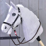 The Hobby Horse LarDen Reins York is a gray plush hobby horse with a white mane and snout, featuring black handmade polypropylene rope reins, mounted on a wooden stick against a wooden panel background.