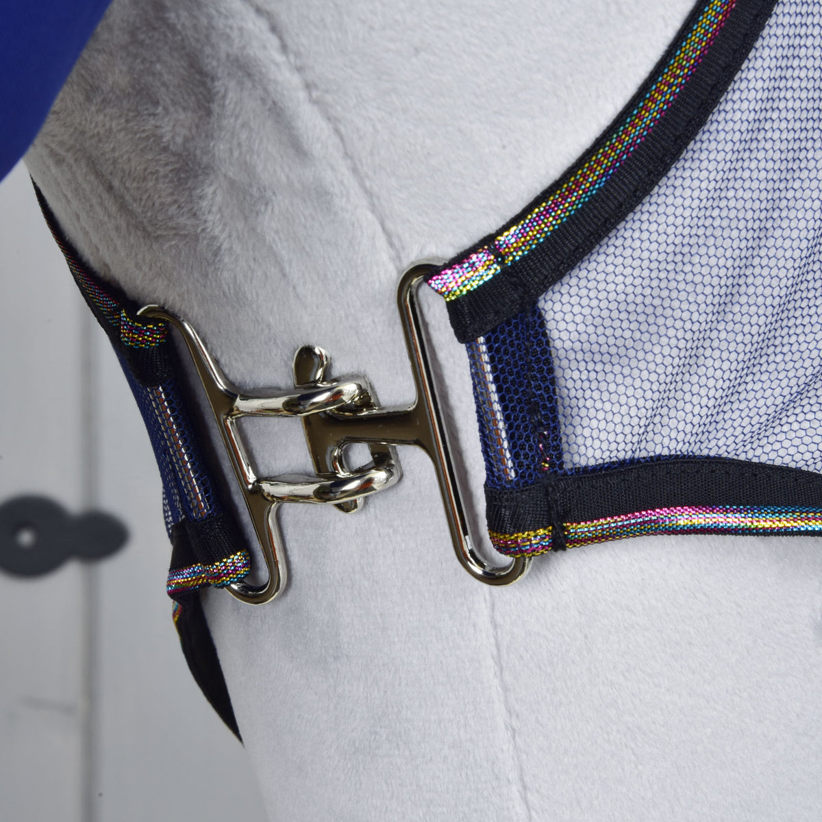 Close-up of a shiny metal clasp securing a mesh strap with colorful trim, part of the Set Fly Combo by Hobby Horse LarDen, shown on a white surface.