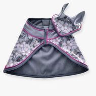 The Set Grey Flower by Hobby Horse LarDen is a gray, floral-patterned pet cape with pink trim and an attached hood featuring two upright bunny-like ears, displayed flat on a white background.