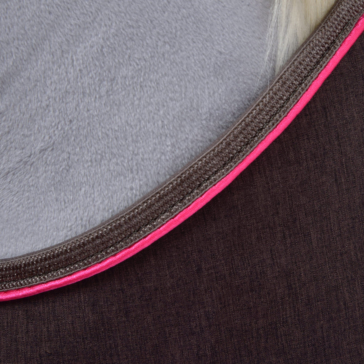Close-up of the brown Hobby Horse blanket fabric with bright pink and brown edge trim