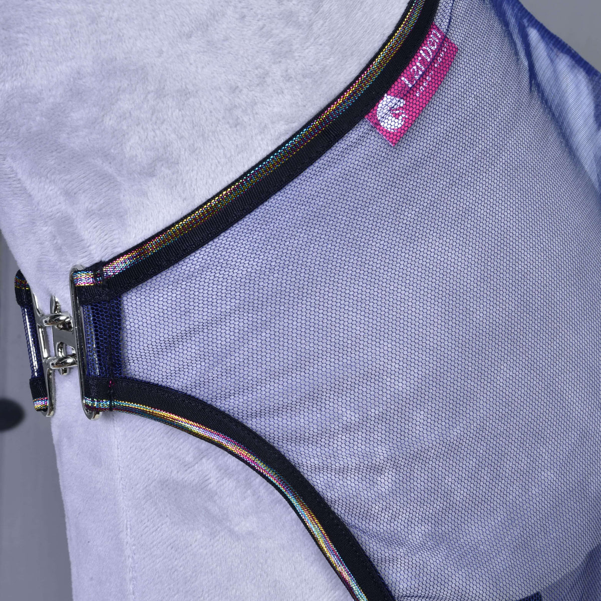 Close-up of the Fly sheet LarDen by Hobby Horse LarDen, a light purple PES pet harness with black trim, metal buckle, and a small pink label on a soft grey surface—ideal for walks or hobby horse adventures.