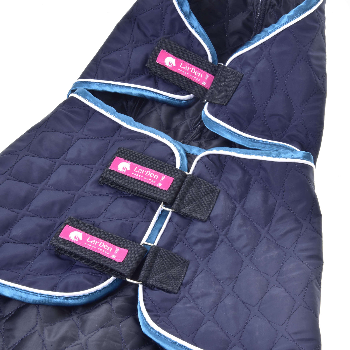 Close-up of three black Velcro straps with pink LarDen labels on the navy quilted Hobby Horse blanket