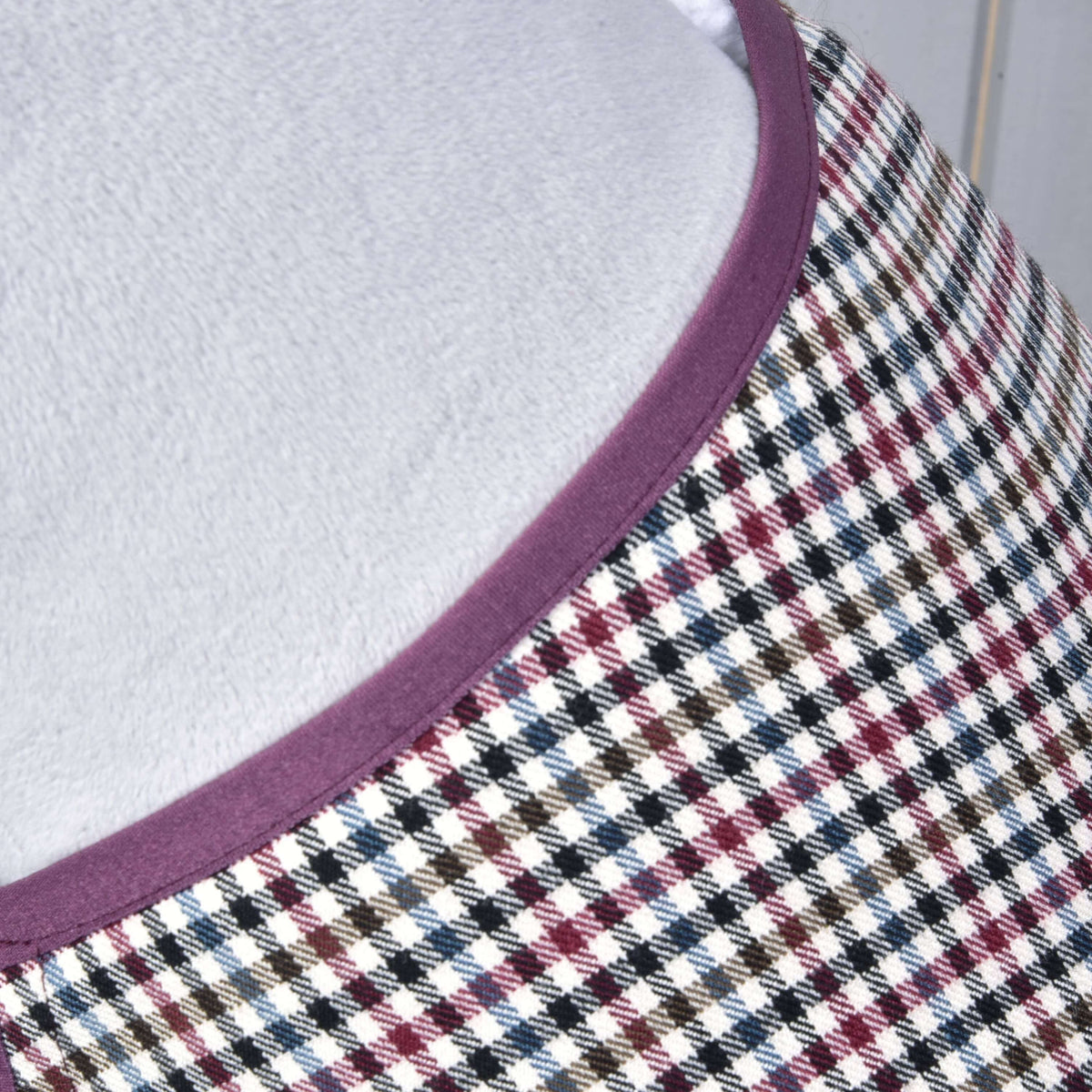 Close-up of the small multicoloured check and plum binding at the neckline of the Hobby Horse Blanket western Colorado