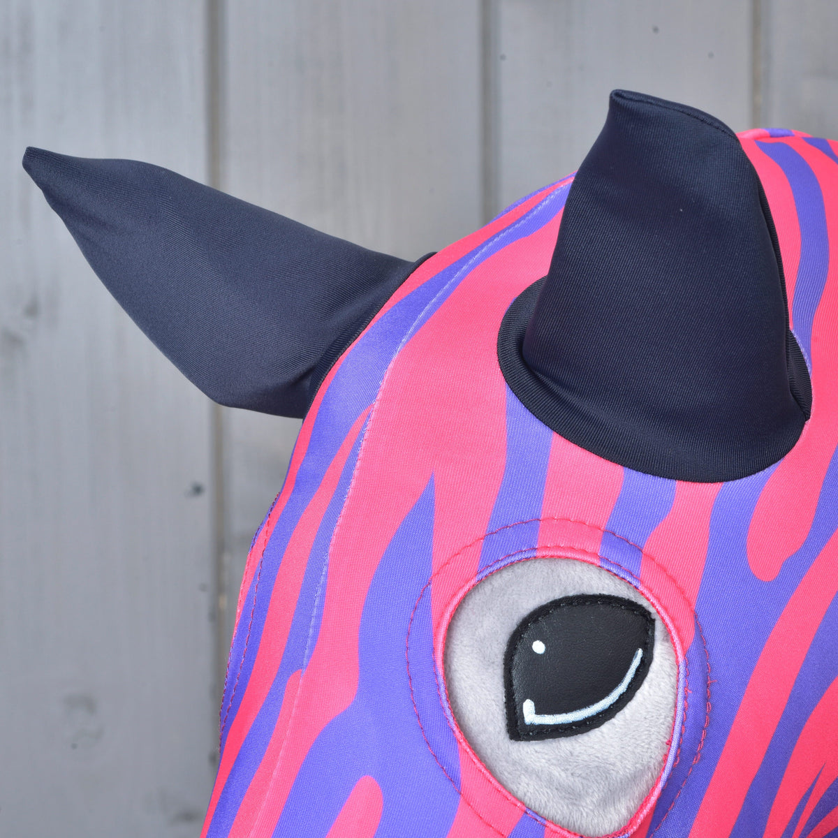 Close-up of the pink and purple lycra protective suit around a Hobby Horse eye and ears