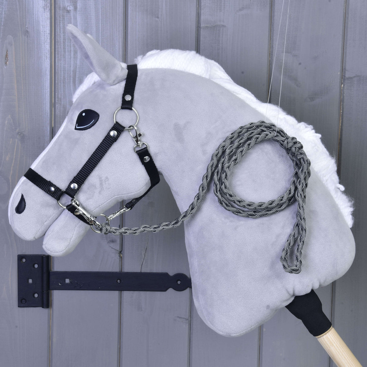 Grey Hobby Horse with white mane and black halter wearing the graphite braided lead rope coiled over its neck
