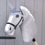 The Hobby Horse LarDen Ear Bonnet Crocheted Grey is showcased on a plush grey hobby horse with a white mane and black bridle, mounted on a wooden stick in front of a light wooden wall.