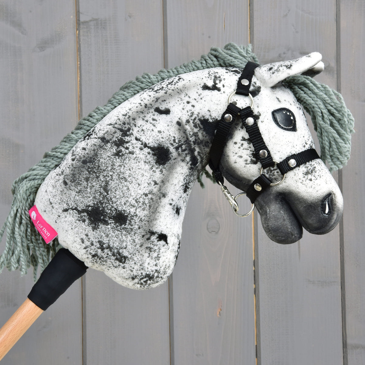 Kæphesten Hobby Horse Hazel vendt mod højre med det lyserøde LarDen-mærke nederst på halsen og grågrøn manke af garn