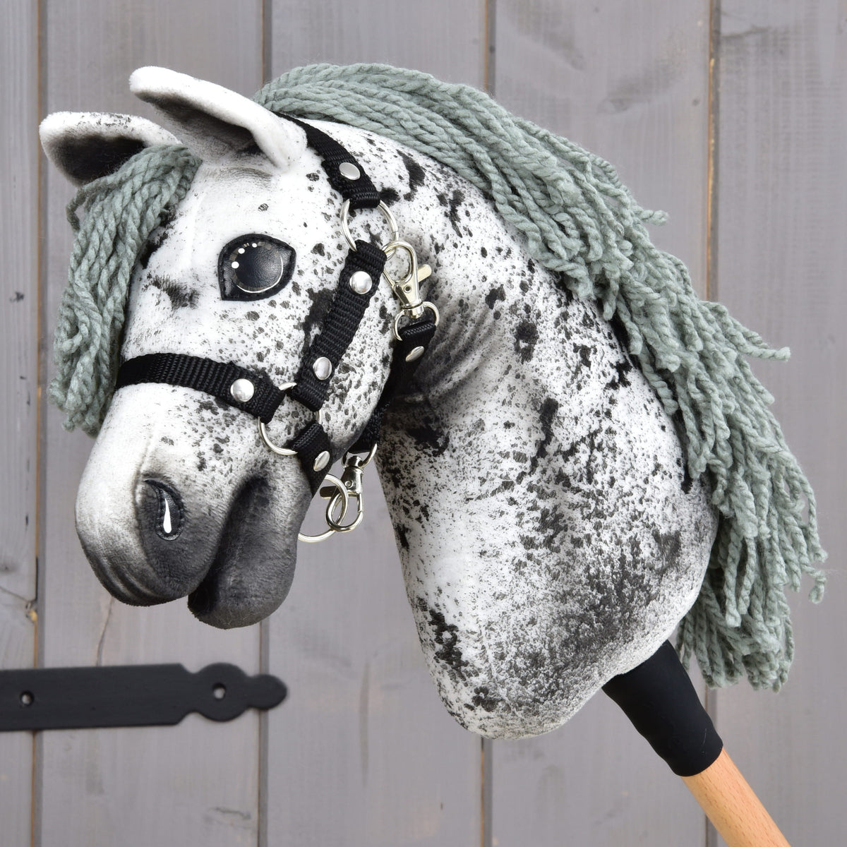 Hobby Horse Hazel fra LarDen, en hvid kæphest i plys med sorte prikker, grågrøn manke af garn og sort grime
