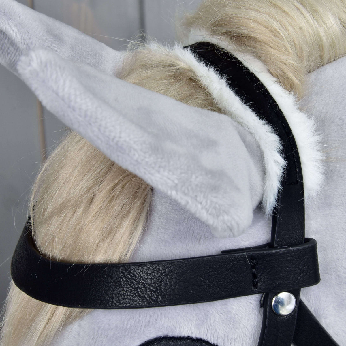 Close-up of a light gray plush horse head wearing Hobby Horse LarDen’s Complete bridle with fur, highlighting the ear, bridle, and fluffy blonde mane details of this realistic hobby horse.