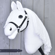 The Hobby Horse LarDen "Hobby Horse Lady with Black Halter" features a white horse with a black halter and long yarn mane on a stick, posed as if ready for dressage in front of a light gray wooden wall.