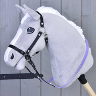 The Hobby Horse LarDen gray plush hobby horse with a white mane, bitless bridle, and Reins rubberized Light purple is mounted on a wooden stick against a paneled wood background.