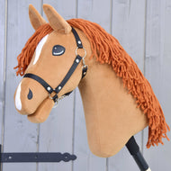 The Hobby Horse LarDen Little Angel with Black Halter has a brown plush head, orange yarn mane, white markings, black halter, and is shown on a stick against a light gray wooden background.