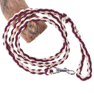 The Hobby Horse LarDen Knitted Lead Rope Maroon features a braided maroon and white paracord with a metal clasp, shown coiled beside a tree branch.