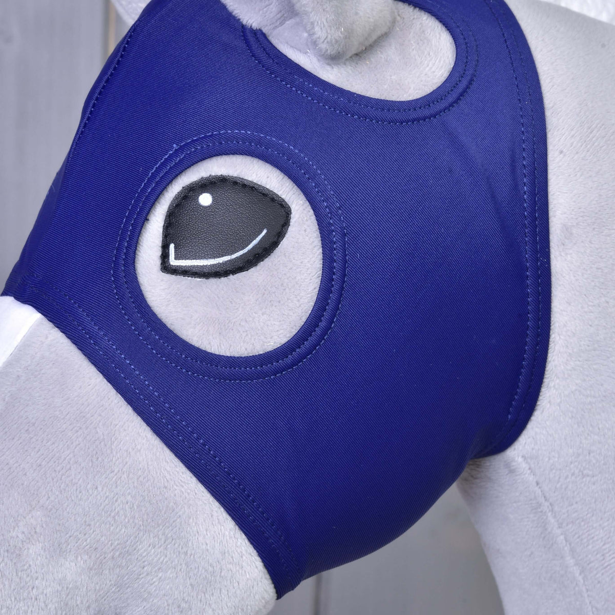 Close-up of the Horse Mask without ears on a Hobby Horse: navy fabric framing the black eye, the ear opening above