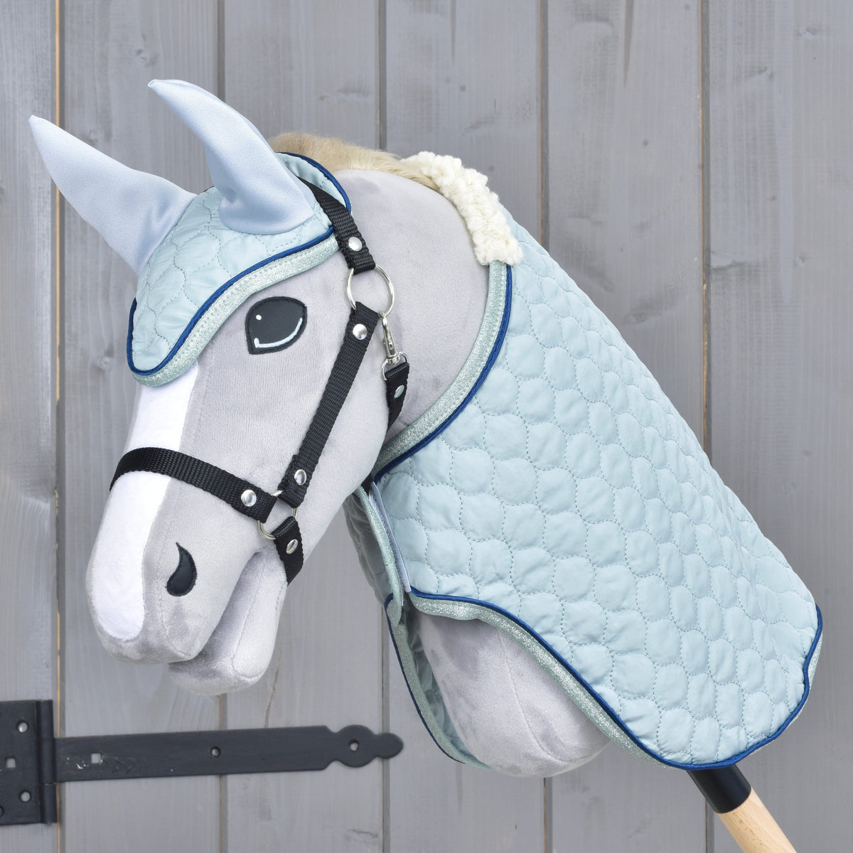 Light blue quilted blanket and ear bonnet set worn by a grey Hobby Horse