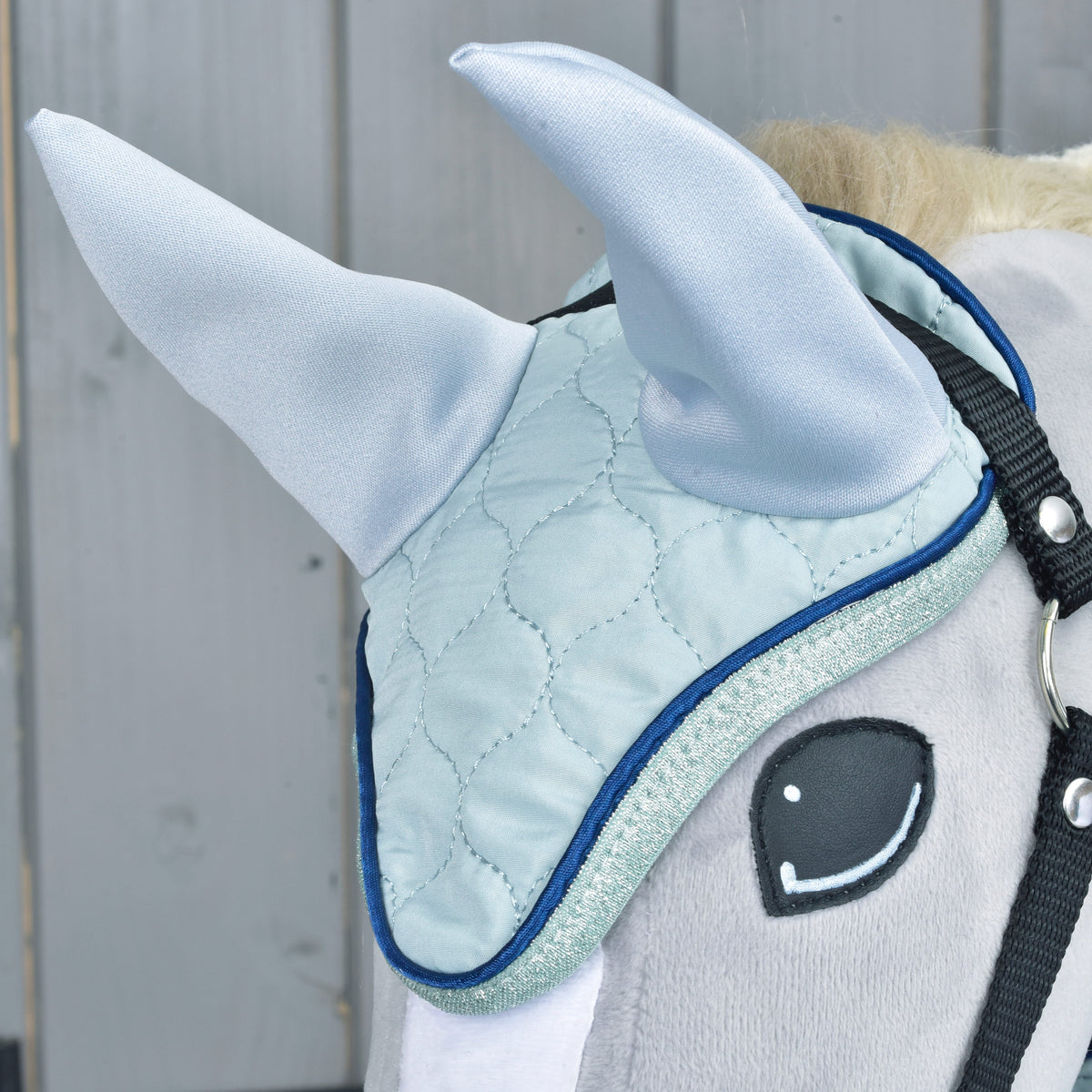 Light blue quilted ear bonnet from Set Mint worn on a grey Hobby Horse