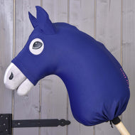 The Hobby Horse LarDen protective suit, featuring a blue Lycra head with white ears and snout plus a black cartoon eye on a wooden stick, stands before a gray wooden wall.