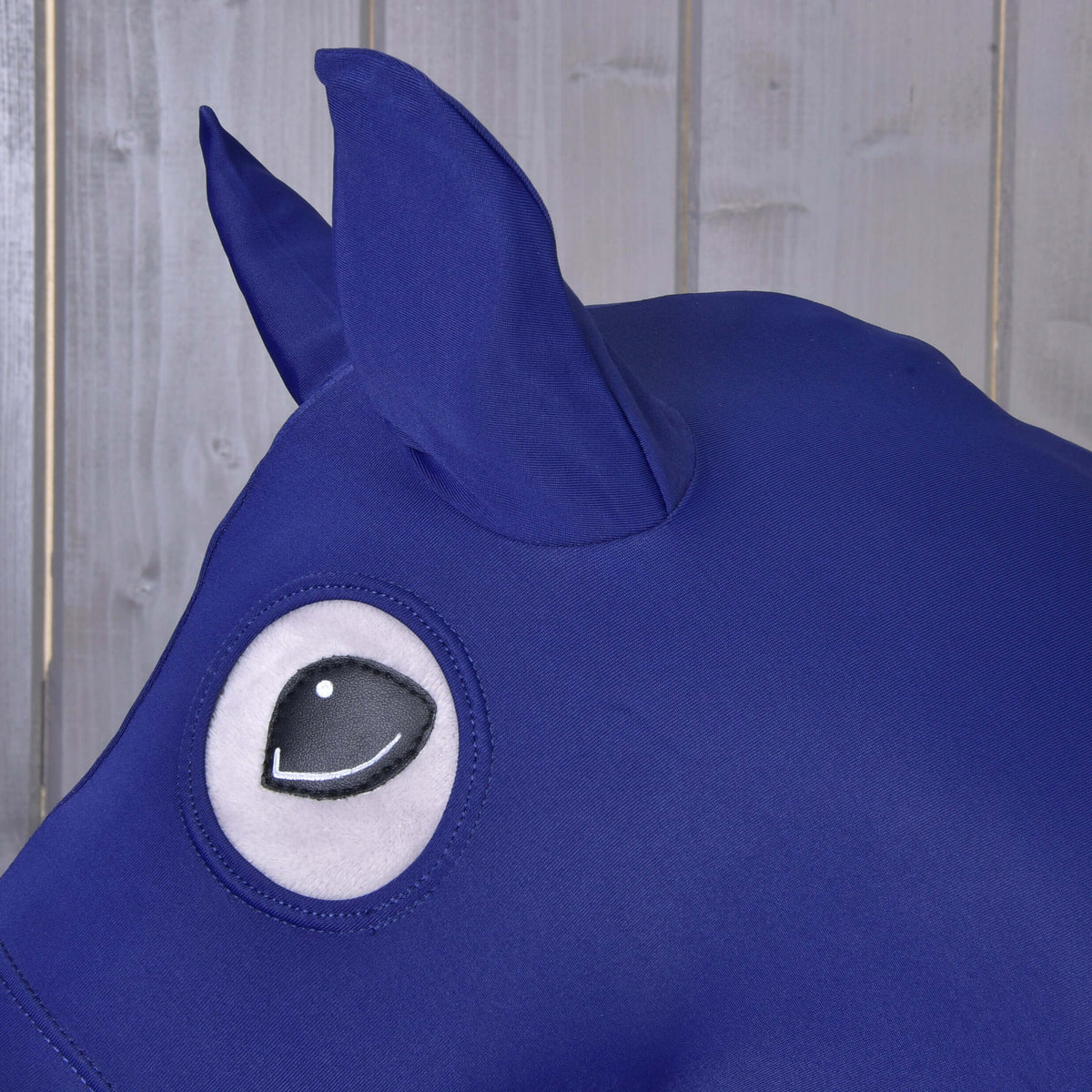 Close-up of the navy lycra ears and round eye opening of the Hobby Horse protective suit, the black eye showing through