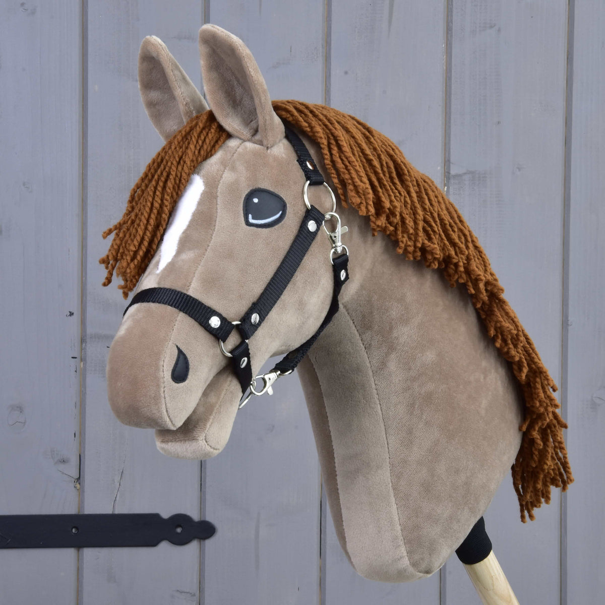 The Hobby Horse LarDen "Oliver" features brown fur, a white blaze, yarn mane, and comes with a black halter plus a free fur halter. It's modeled after an Oldenburg stallion and mounted on a wooden stick.
