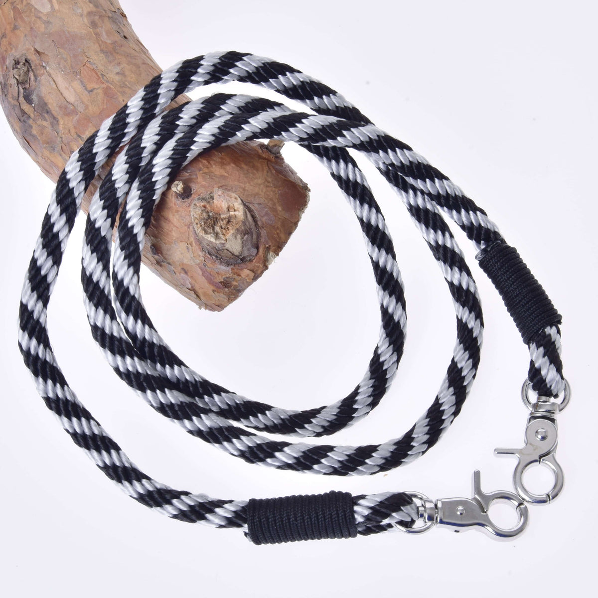 The Hobby Horse LarDen "Hobby Horse - Reins black stripe" is a black and white striped polypropylene rope leash with metal clips on both ends, shown coiled on wood against a white background—perfect for hobby horse or handmade reins.