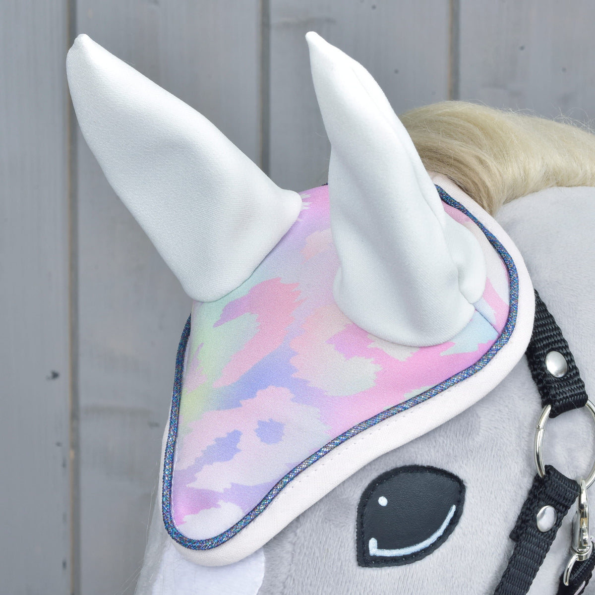 Pastel patterned ear bonnet from the set worn on a grey Hobby Horse