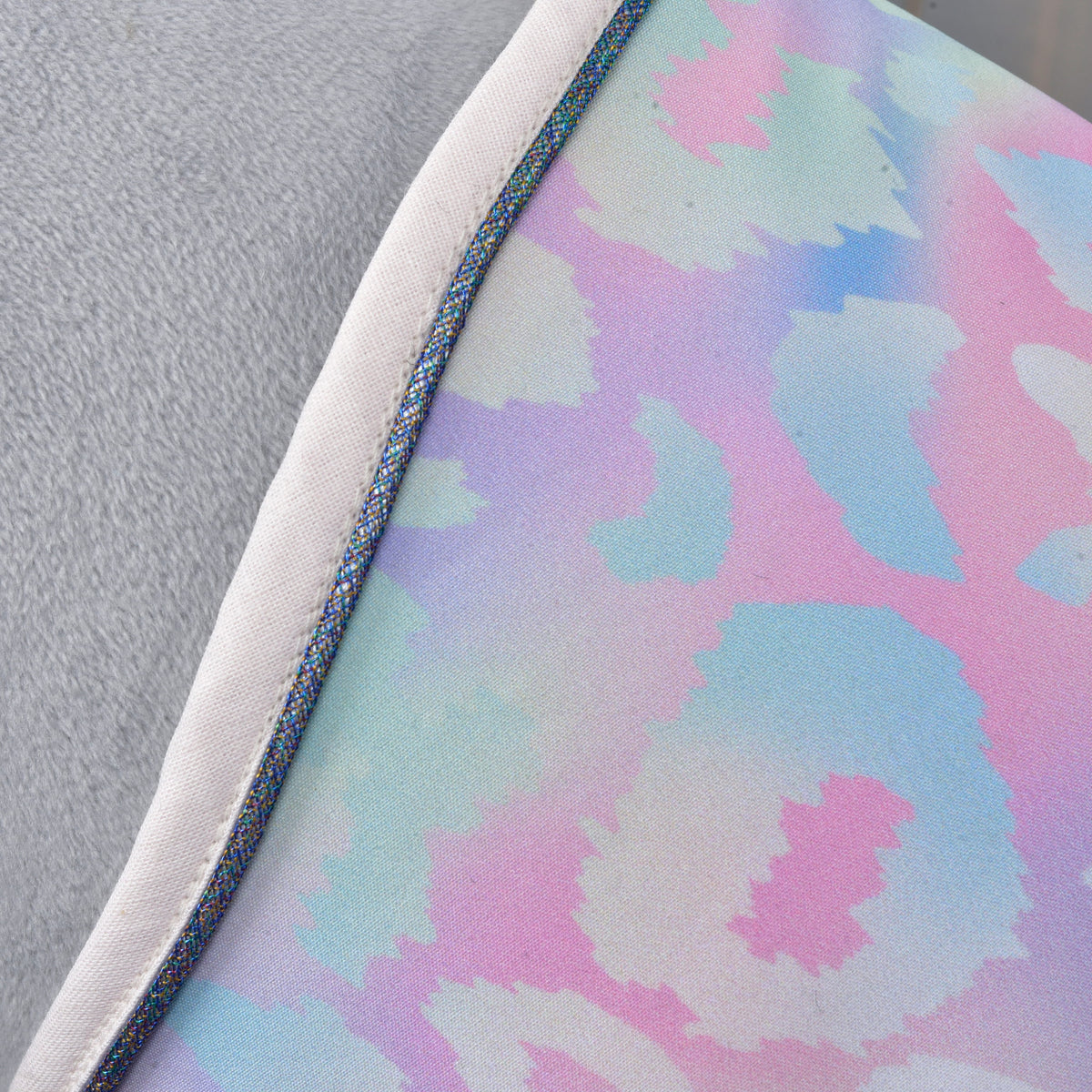 Close-up of the pastel pattern and blue trimmed edge of the Hobby Horse blanket