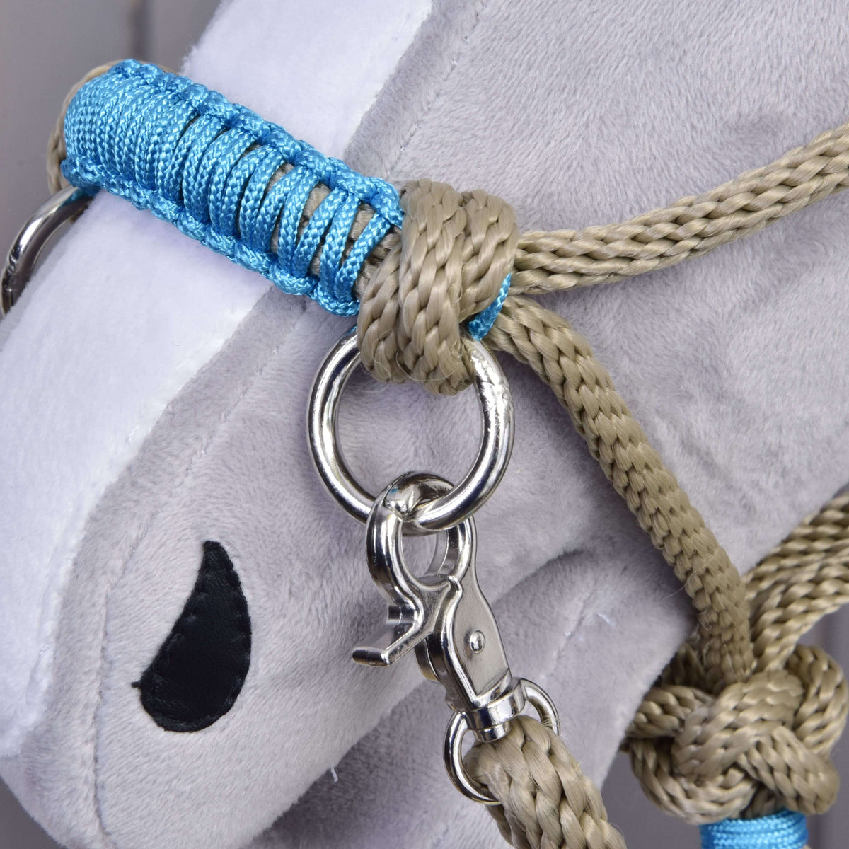 Close-up of a plush gray Hobby Horse LarDen head wearing the Rope set Nature Blue, featuring a blue and beige halter with metal ring and clip, black embroidered eye, white snout, and matching attached reins.