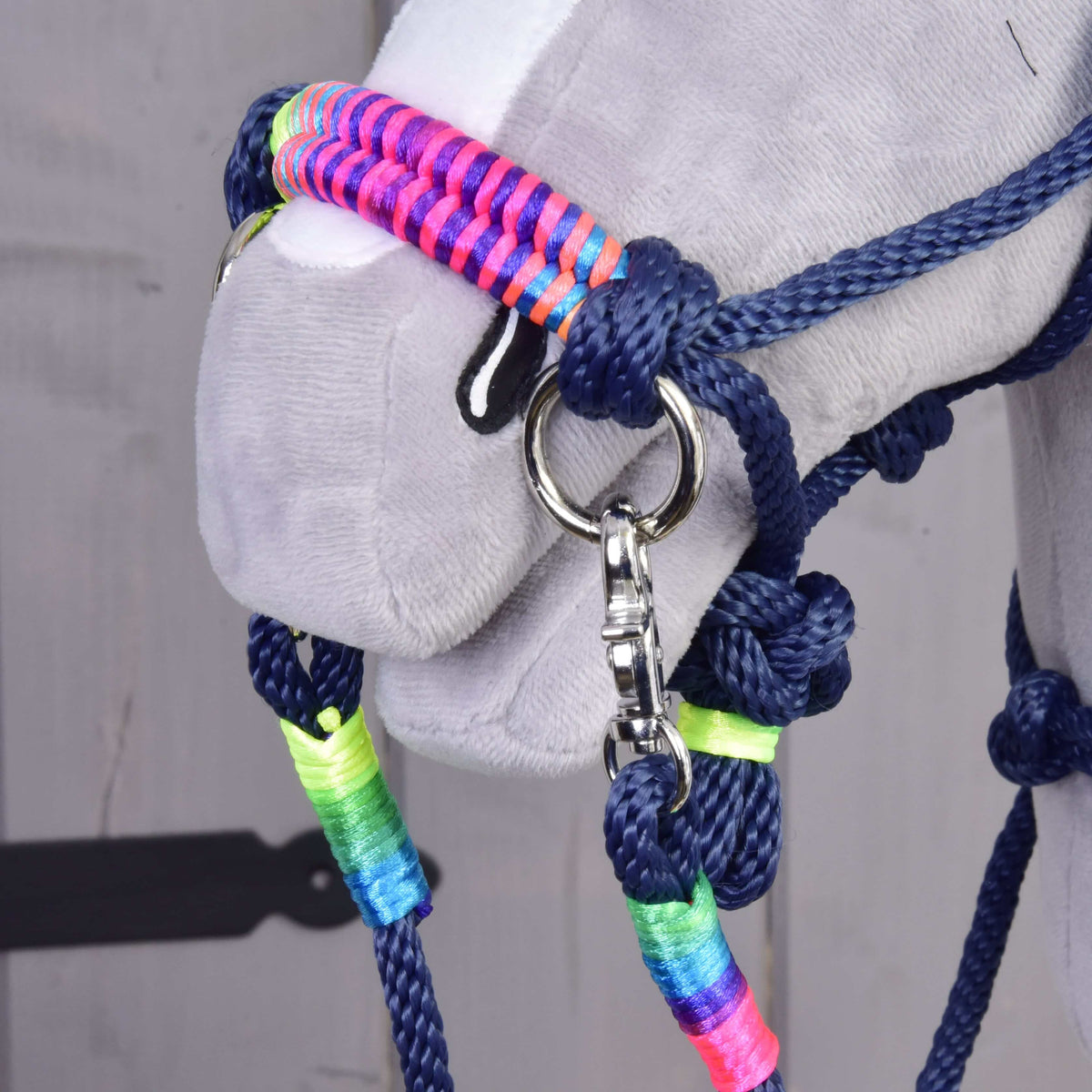Close-up of a horse wearing the Rope set Rosemary by Hobby Horse LarDen, a navy halter with neon green, blue, pink, and rainbow thread accents plus a metal clip—perfect to pair with colorful reins.