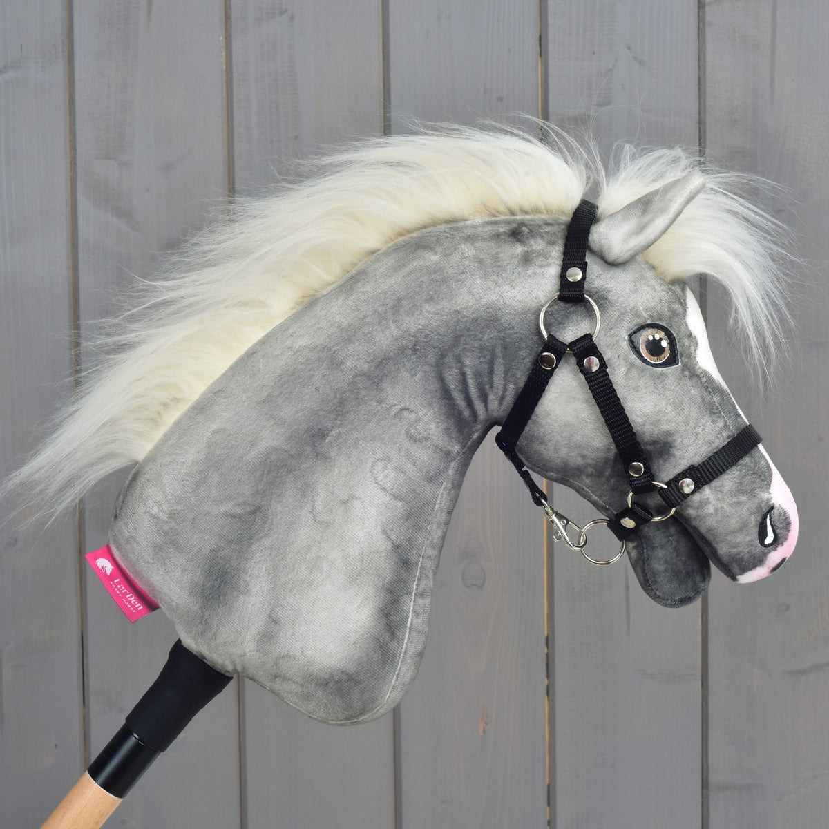 Hobby Horse Silver Moon from the right, mottled grey plush neck, cream mane and a pink LarDen label above the stick