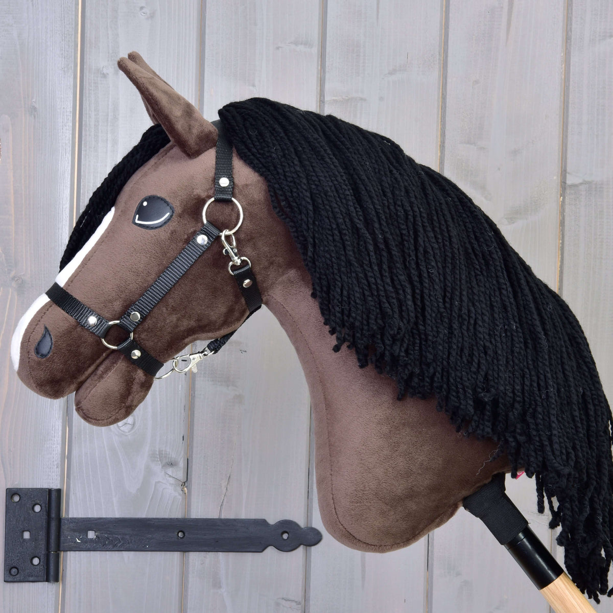 The Hobby Horse LarDen "Sisi with Black Halter" features a plush brown body, white stripe, and black yarn mane on a wooden stick—perfect for aspiring Hanoverian sport horse or performance mare dreams.
